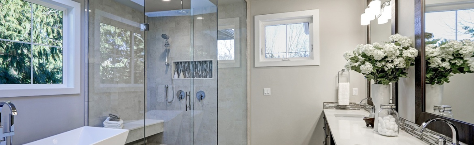 Beige bathroom with a corner cabin and a tree behind the window