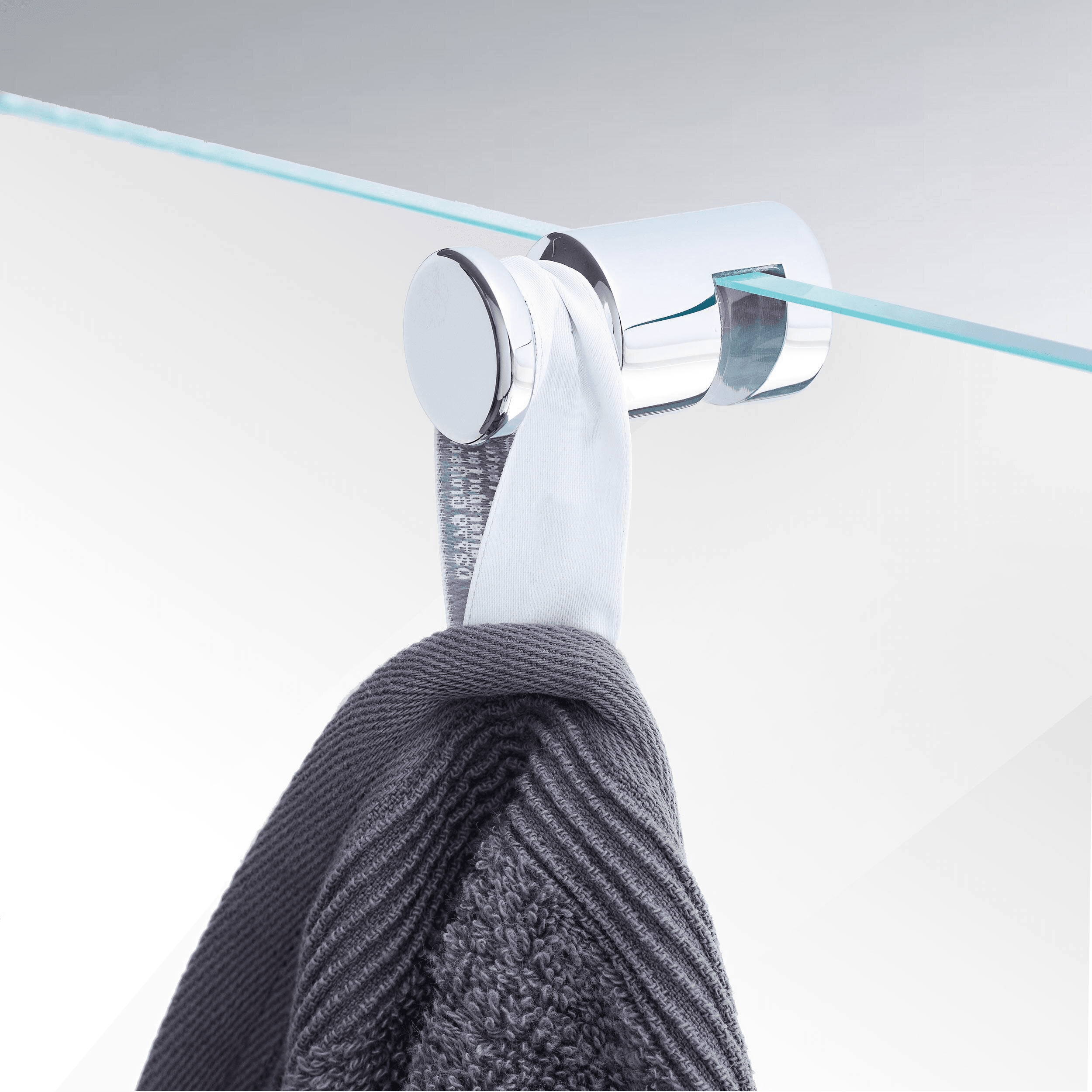 Towel holder in chrome on a glass door with a towel